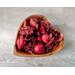 Handmade wooden bowl in a heart shape, displaying aromatic apple cinnamon potpourri against a rustic grey background